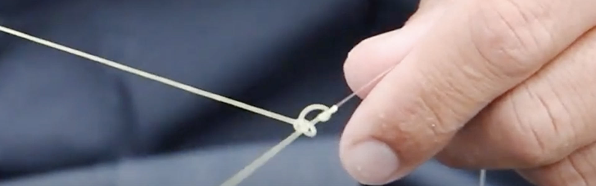 close up of a person tying a complex fishing knot
